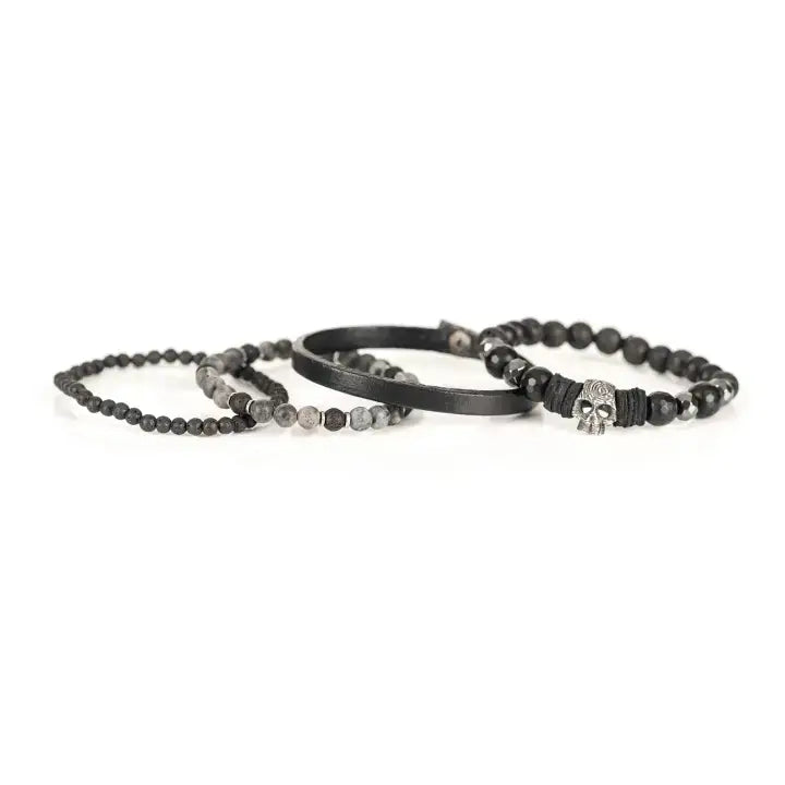 Black multi-layer men’s bracelet set featuring faceted black onyx beads, lava stone accents, black leather band, and silver skull centerpiece on a light background.