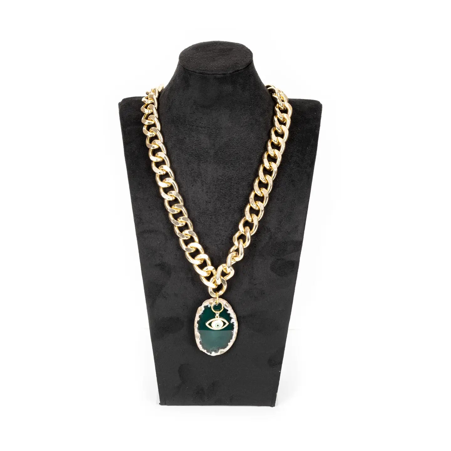 Gold chunky chain necklace with green stone pendant and evil eye charm on white background.