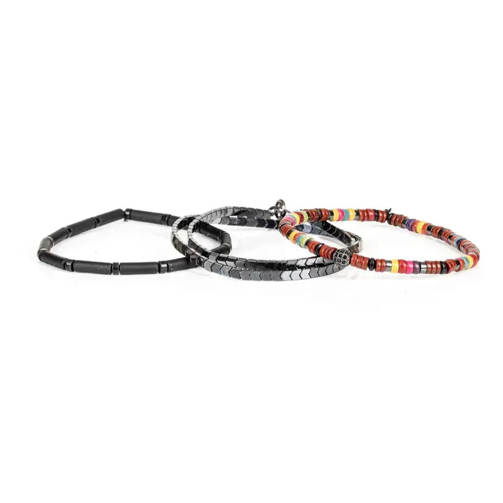 Multicolor multi-layer men’s bracelet featuring colorful disc beads, metallic hematite chevron strands, matte black tubular beads, and crystal centerpiece accent on a light background.