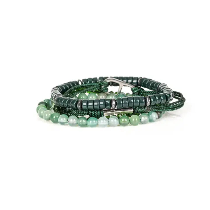 Men’s layered bracelet set featuring dark green heishi beads, green braided cord with a silver-tone centerpiece, faceted green crystal beads, and polished green natural stone beads, stacked in a sophisticated contemporary luxury design on a white background.