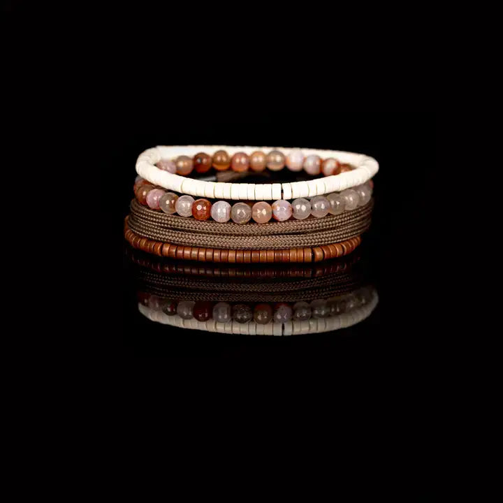 Men’s layered bracelet set featuring brown braided cord, brown heishi beads, polished black metal accents, warm-toned natural stone beads, and white heishi beads, stacked in a refined earthy luxury design on a white background.