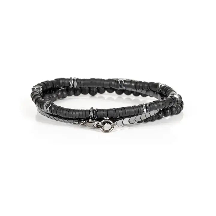 Black multi-layer men’s bracelet featuring hematite disc strands, shield-pattern metallic beads, pyramid-cut spacers, and lava stone bead accents on a light background.