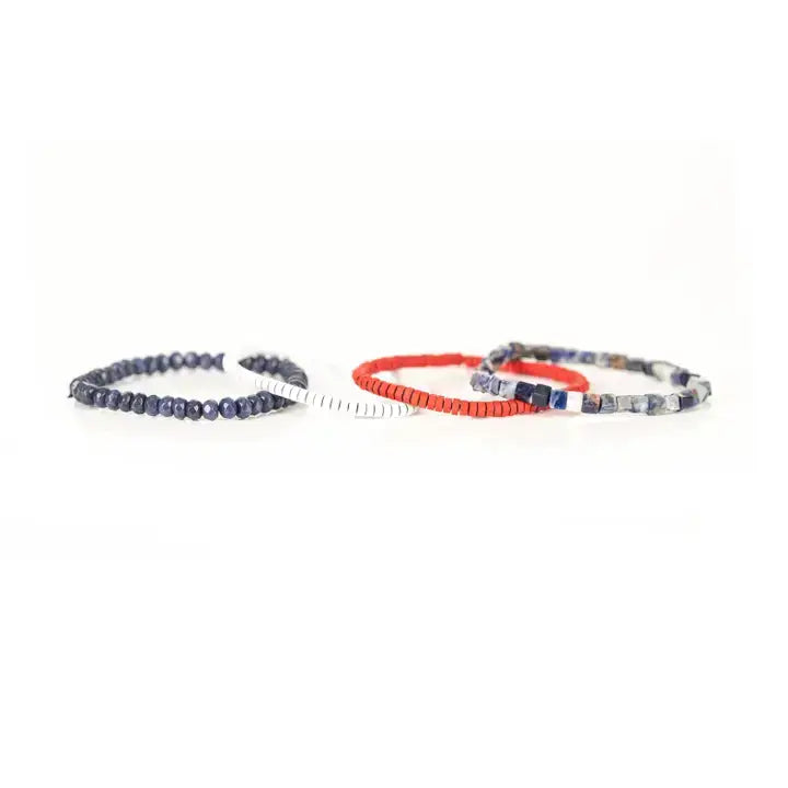 Blue, red, and white multi-layer men’s bracelet set featuring faceted blue beads, natural stone cube beads, and layered colorful disc bead strands on a light background.