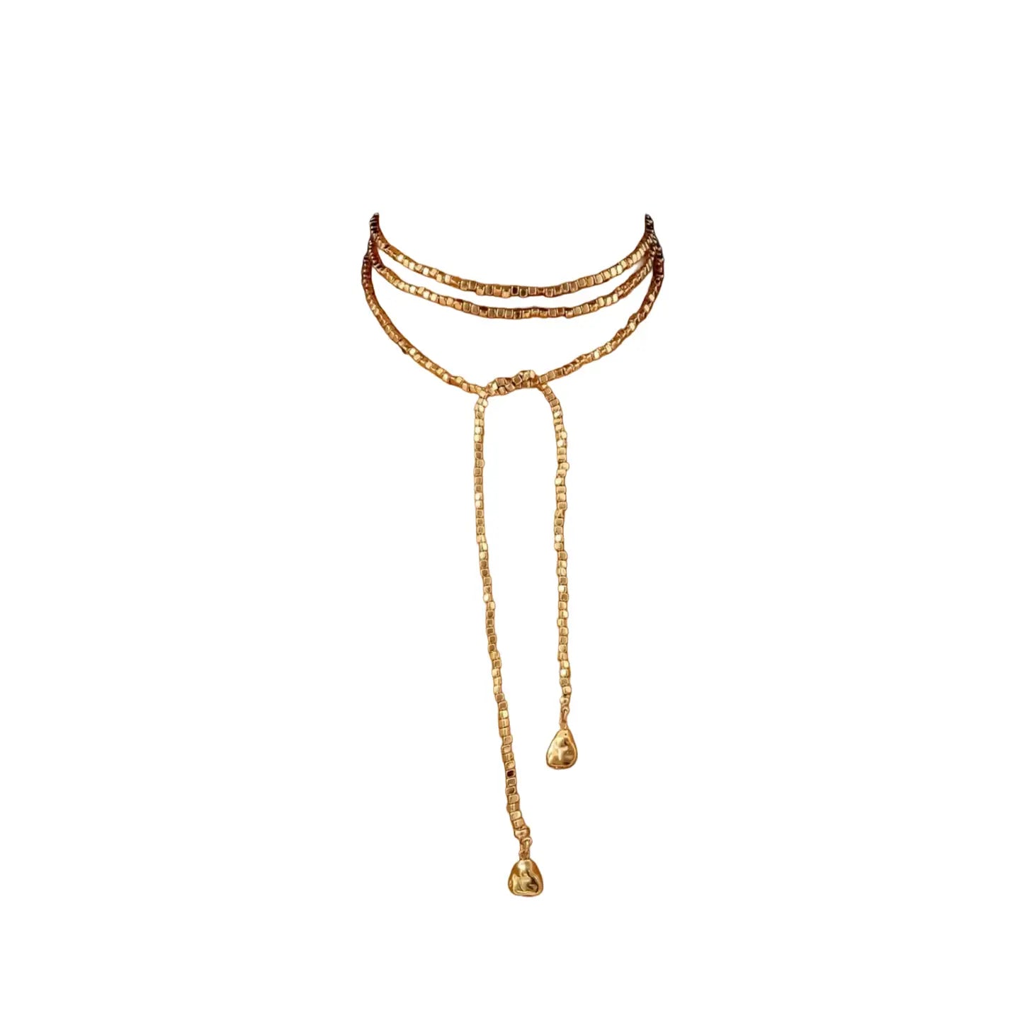 Layered gold necklace with three strands and long lariat drop chains ending in sculpted gold pendants on a white background.