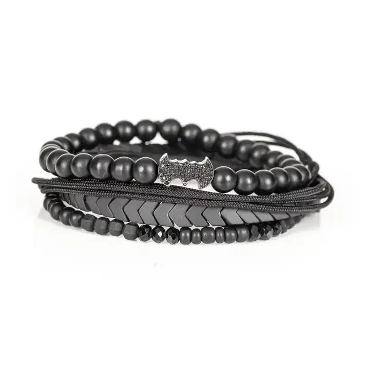 Black layered men’s bracelet set with matte black beads, Batman-inspired centerpiece, chevron metallic beads, crystal accents, and braided rope wraps on white background.