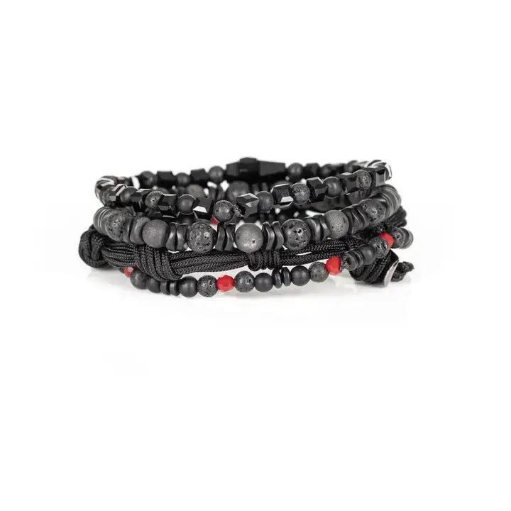 Black multi-layer men’s bracelet set featuring lava stone beads, faceted black onyx, braided rope bands, black cross centerpiece, and subtle red accent beads on a light background.