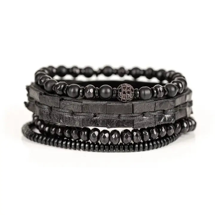 Black multi-layer men’s bracelet featuring woven leather band, matte onyx beads, faceted black crystal stones, crystal centerpiece accent, and hematite bead strand on a light background.