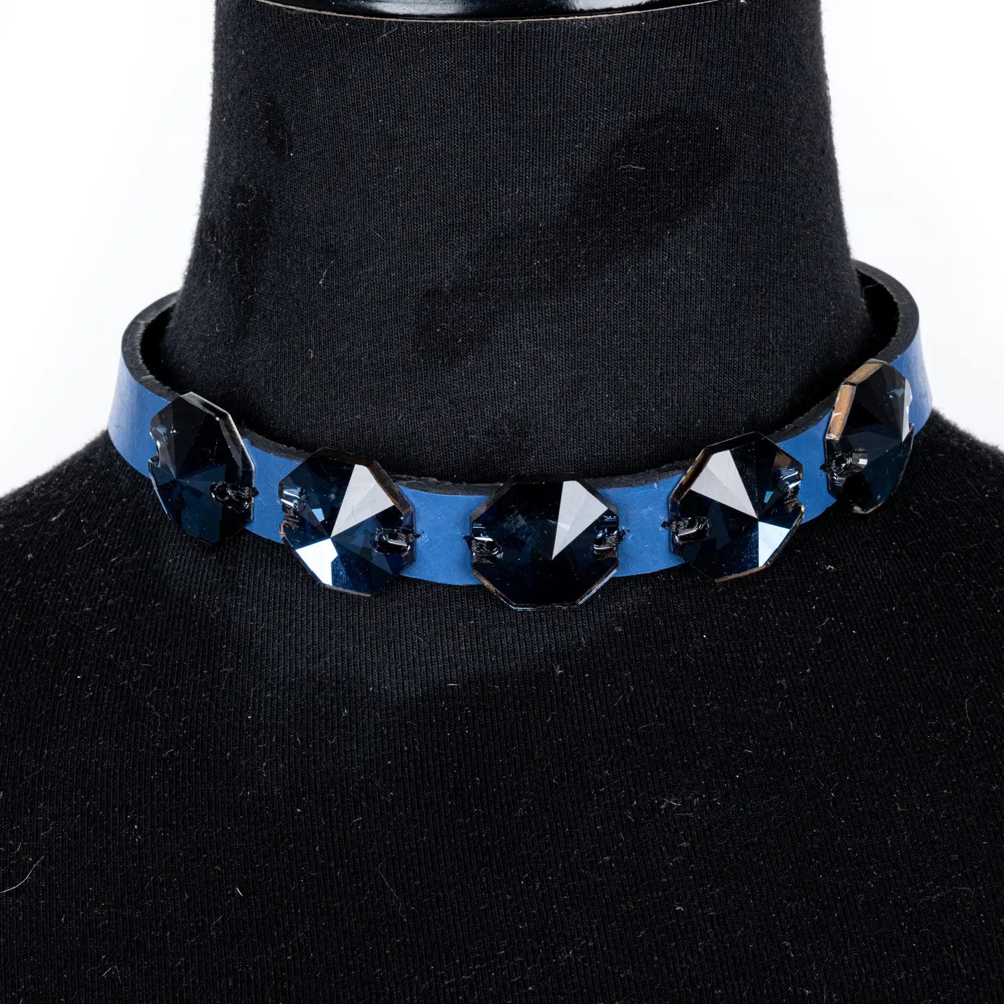 Black leather choker with a row of dark geometric faceted crystals across the front, displayed on a white background.