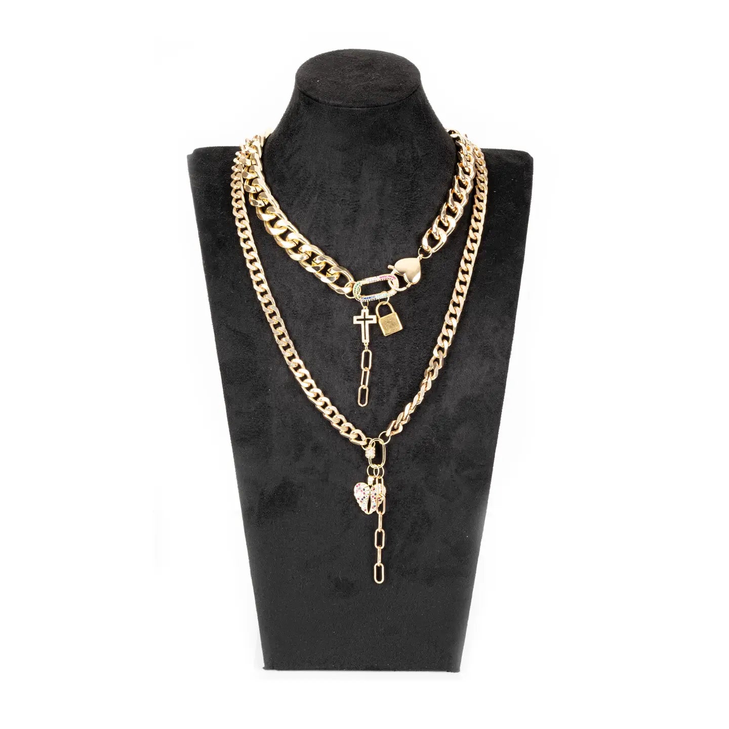 Layered gold chain necklace with cross, lock and heart charms on white background.