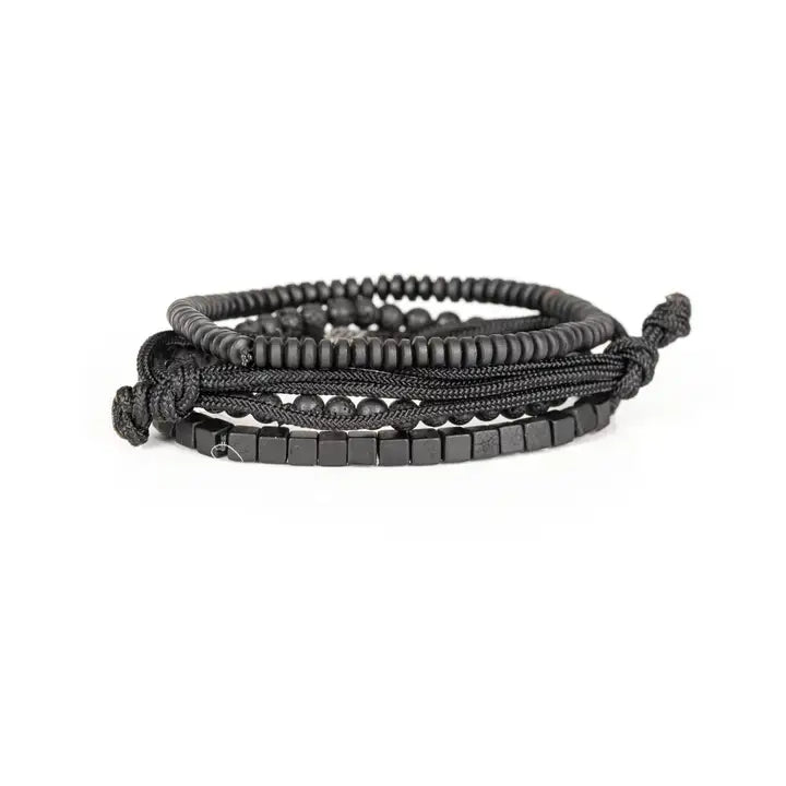 Black layered men’s bracelet set with lava stone beads, cube spacer beads, braided rope wraps, and pavé square centerpiece on white background.