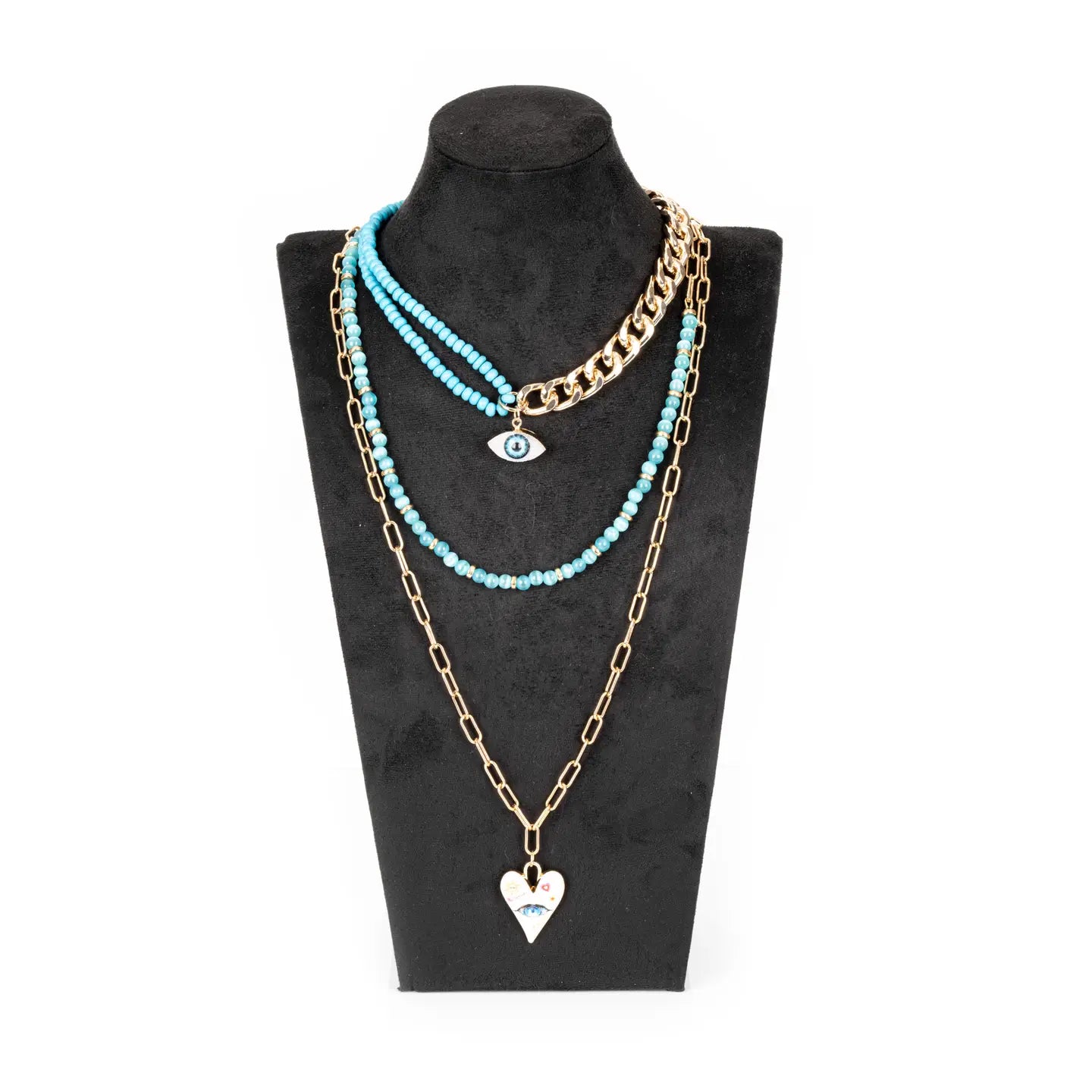 Layered turquoise and gold necklace with evil eye charm and heart pendant on white background.