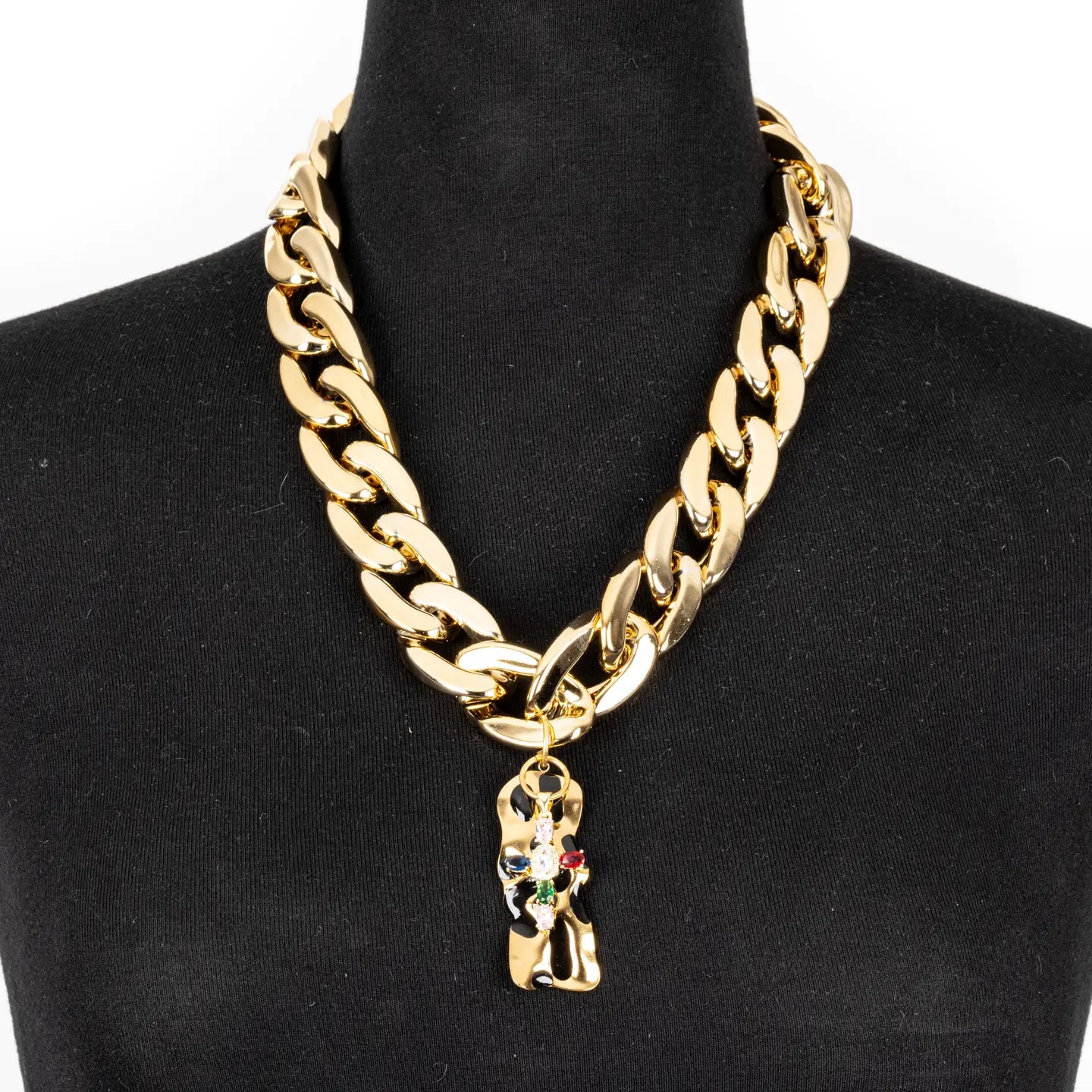 Gold chunky chain necklace with sculptural abstract pendant and subtle crystal accents on white background.