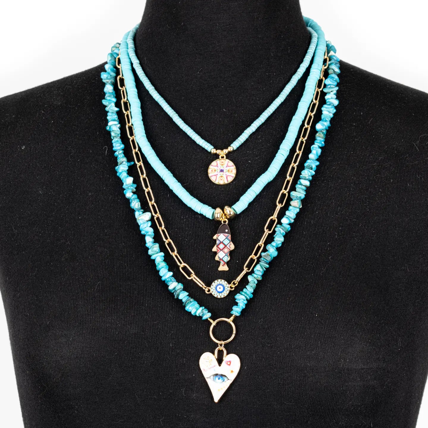 Layered turquoise beaded necklace with multiple strands, gold chain accents, and charm pendants, displayed on a white background.