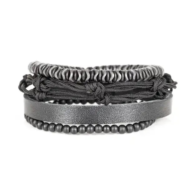 Black multi-layer men’s bracelet featuring hematite disc beads, braided black rope layers, smooth black leather band, and matte black bead strand on a light background.