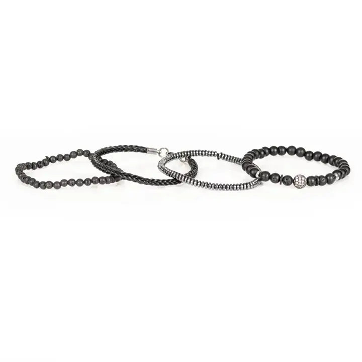 Black layered men’s bracelet set with lava stone beads, braided leather, hematite accents, matte black beads, and pavé centerpiece on white background.