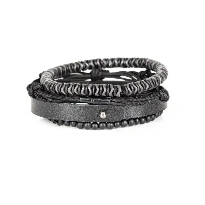 Black multi-layer men’s bracelet featuring hematite disc beads, braided black rope layers, smooth black leather band, and matte black bead strand on a light background.