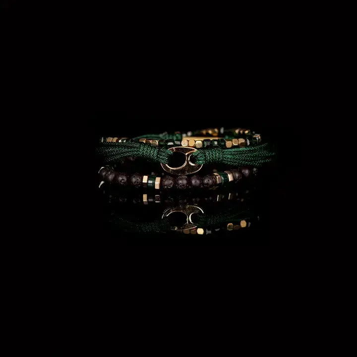 Men’s layered bracelet set featuring dark green braided cord, green crystal beads, gold-tone geometric spacer beads, matte black lava stone beads, and a polished gold-tone centerpiece, stacked in a refined green and gold luxury design on a white background.