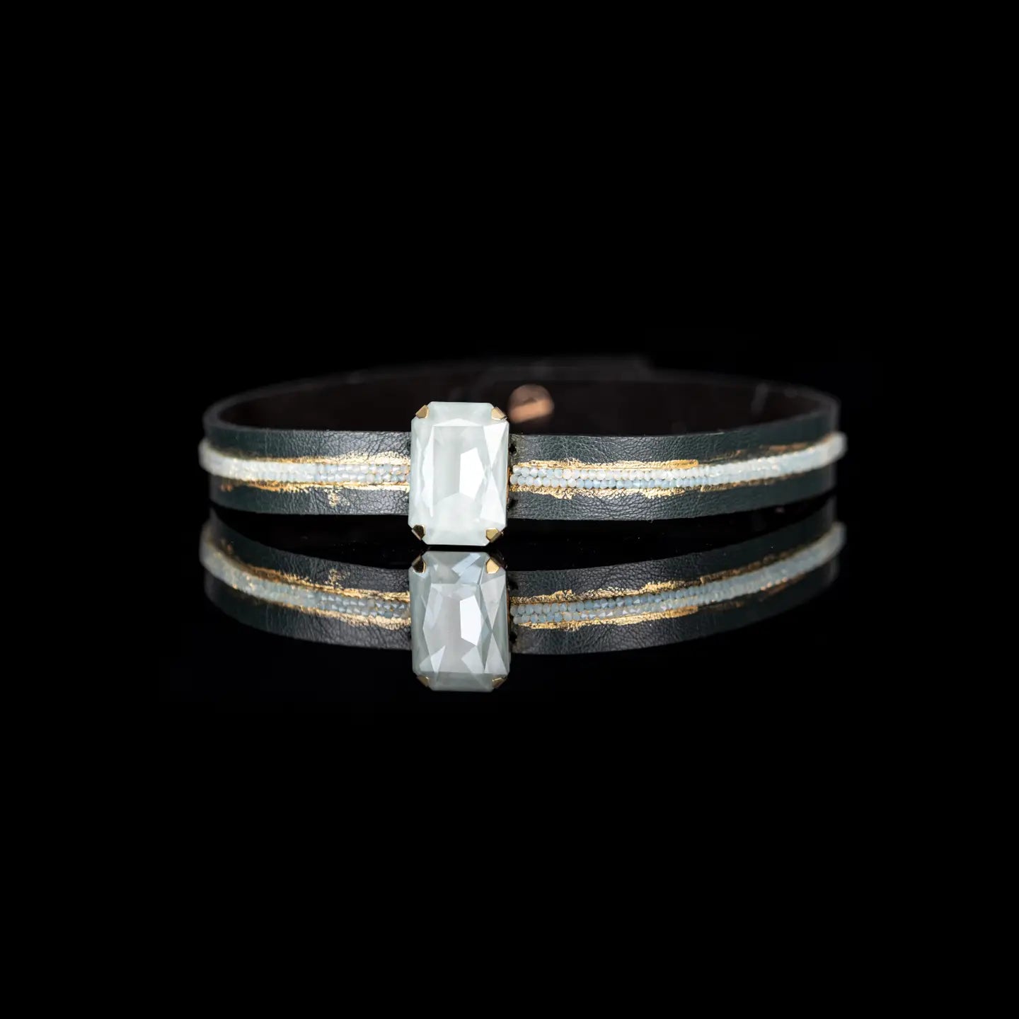 Black leather choker with a central rectangular white crystal and subtle gold and crystal detailing, displayed on a white background.