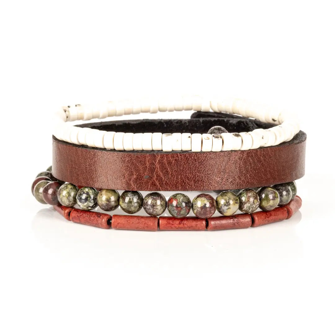 Men’s layered bracelet set featuring a brown genuine leather cuff, white howlite heishi beads, green and burgundy dragon blood jasper beads, and red cylindrical stone beads, stacked in a rugged earthy luxury design on a white background.