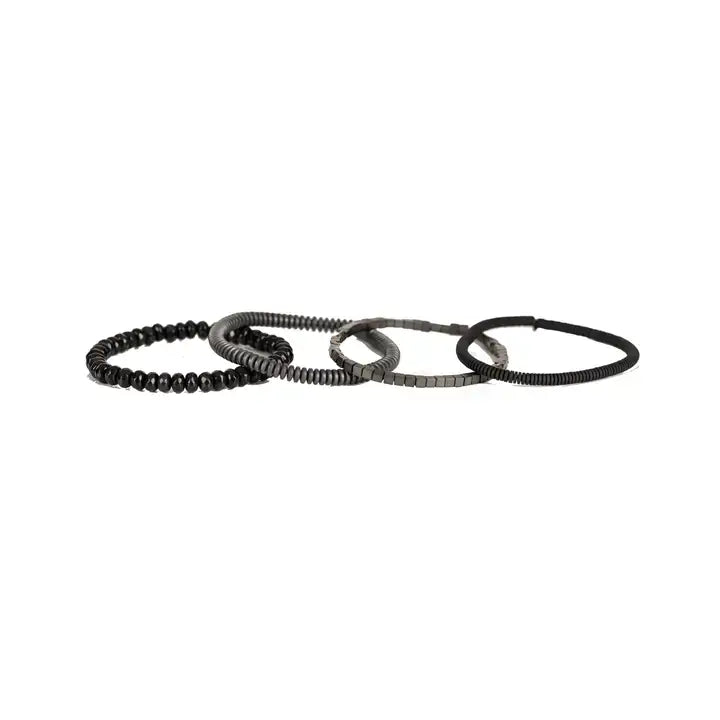 Men's black and gunmetal layered bracelet set featuring black leather, matte black heishi beads, gunmetal cube beads, metallic disc beads, and faceted black crystal beads in a sleek stacked design on a white background.