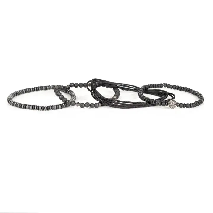 Black multi-layer men’s bracelet featuring matte black beads, lava stone accents, crystal centerpiece bead, braided rope layers, faceted metallic details, and hematite disc strands on a light background.