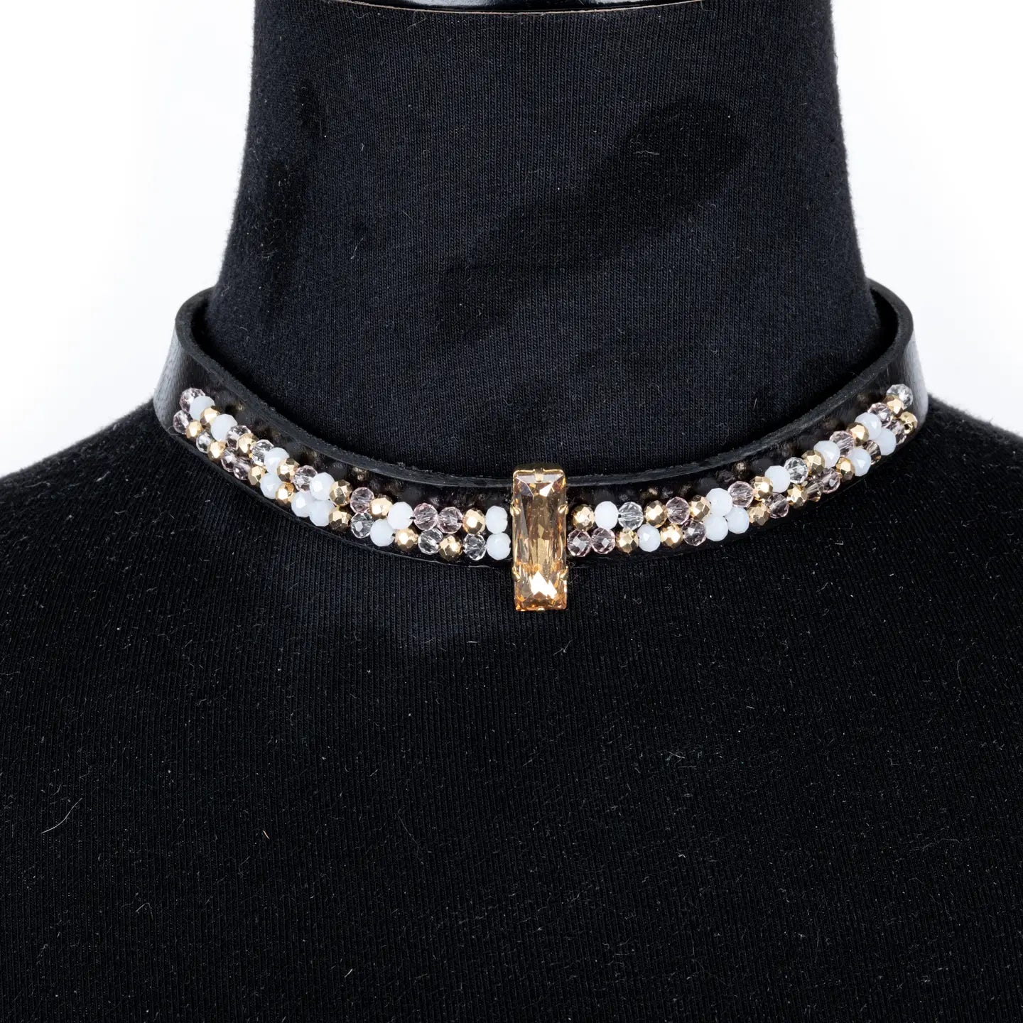 Black leather choker with a central champagne crystal and mixed white and gold crystal detailing along the band, displayed on a white background.