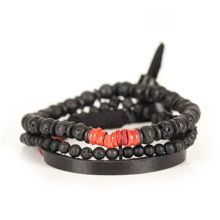 Black multi-layer men’s bracelet set featuring lava stone beads, matte black onyx, layered black strands, and bold red accent beads on a light background.