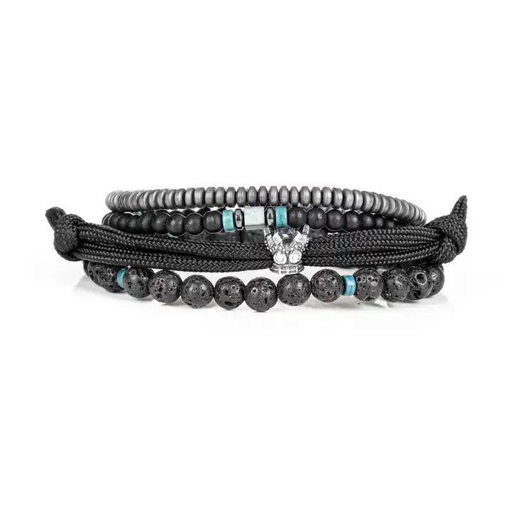 Black layered men’s bracelet set with lava stone beads, braided rope wraps, hematite accents, and turquoise detail on white background.