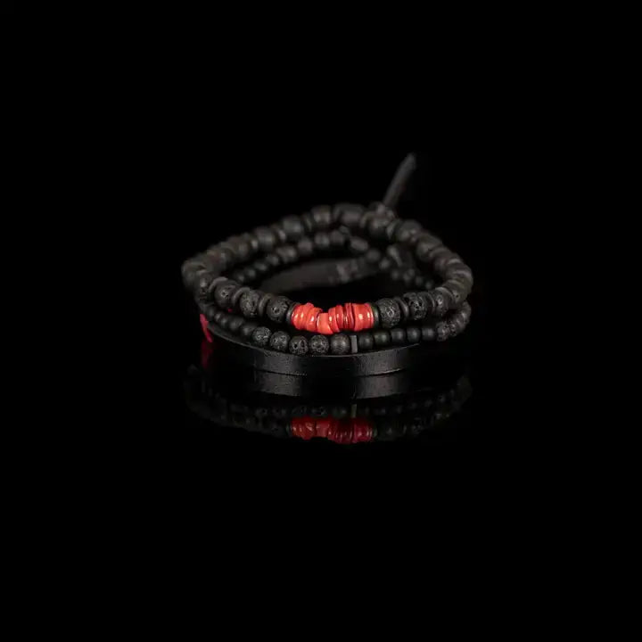 Black multi-layer men’s bracelet set featuring lava stone beads, matte black onyx, layered black strands, and bold red accent beads on a light background.