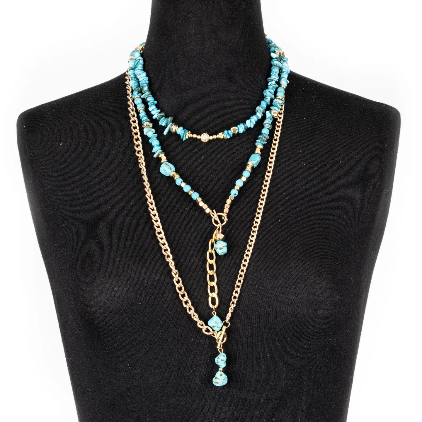 Layered turquoise beaded necklace with gold chain and drop pendant on white background.