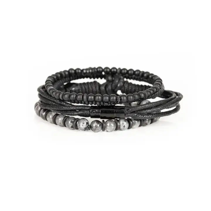 Black layered men’s bracelet set with matte black beads, braided rope wraps, and gray marbled stone accents on white background.
