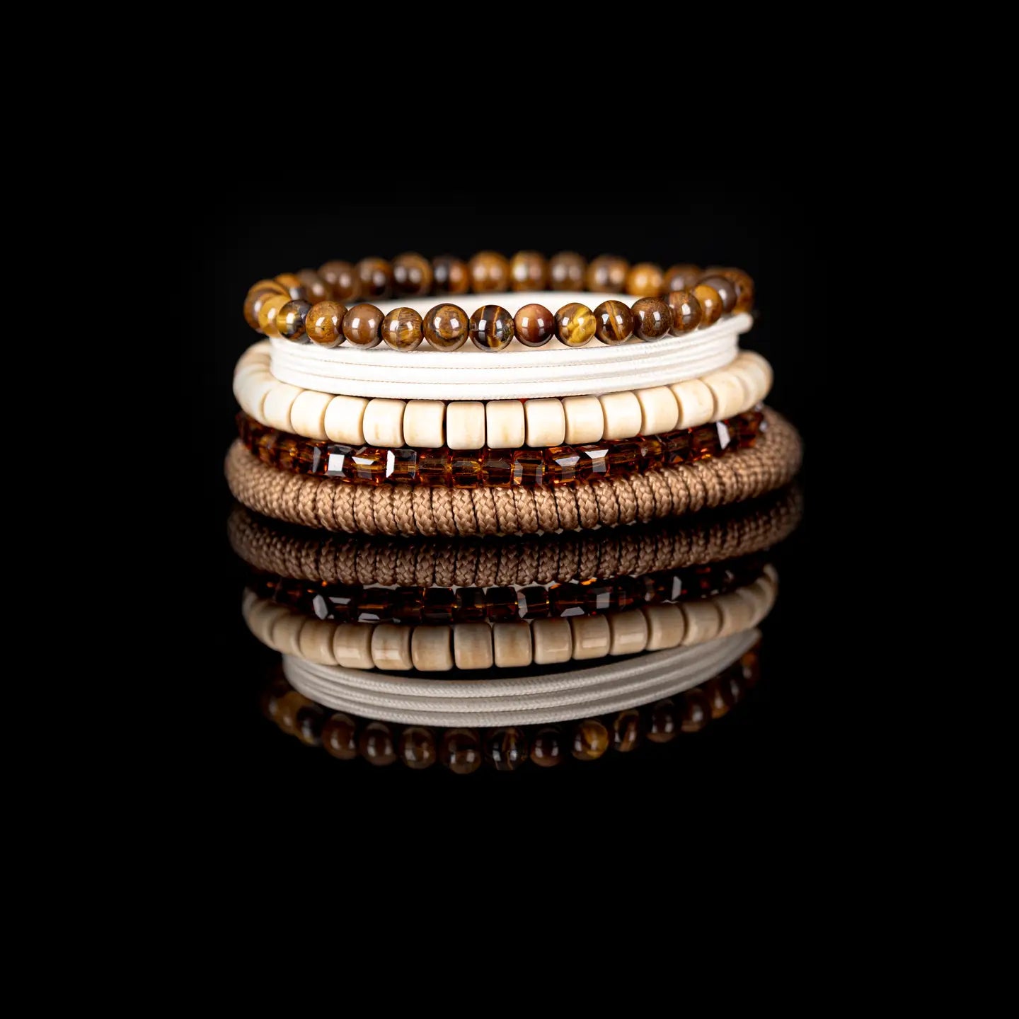 Men’s layered bracelet set featuring tiger’s eye stone beads, ivory heishi beads, amber crystal rectangle beads, cream braided cord wraps, and natural beige accents, stacked in a refined earthy luxury design on a white background.