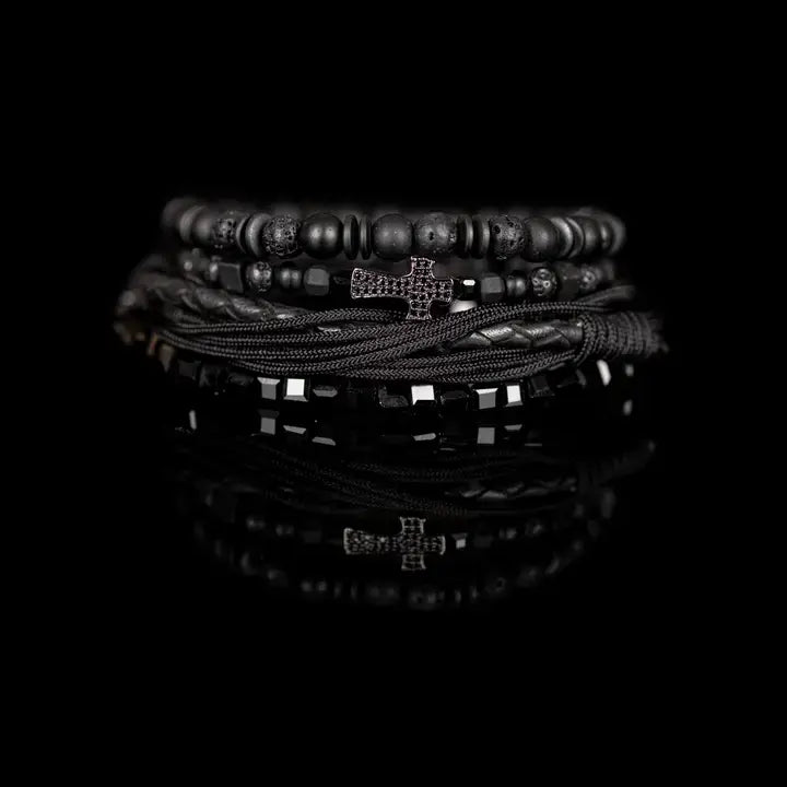 Black layered men’s bracelet set with lava stone beads, braided leather, rope wraps, faceted crystal accents, and pavé cross detail on white background