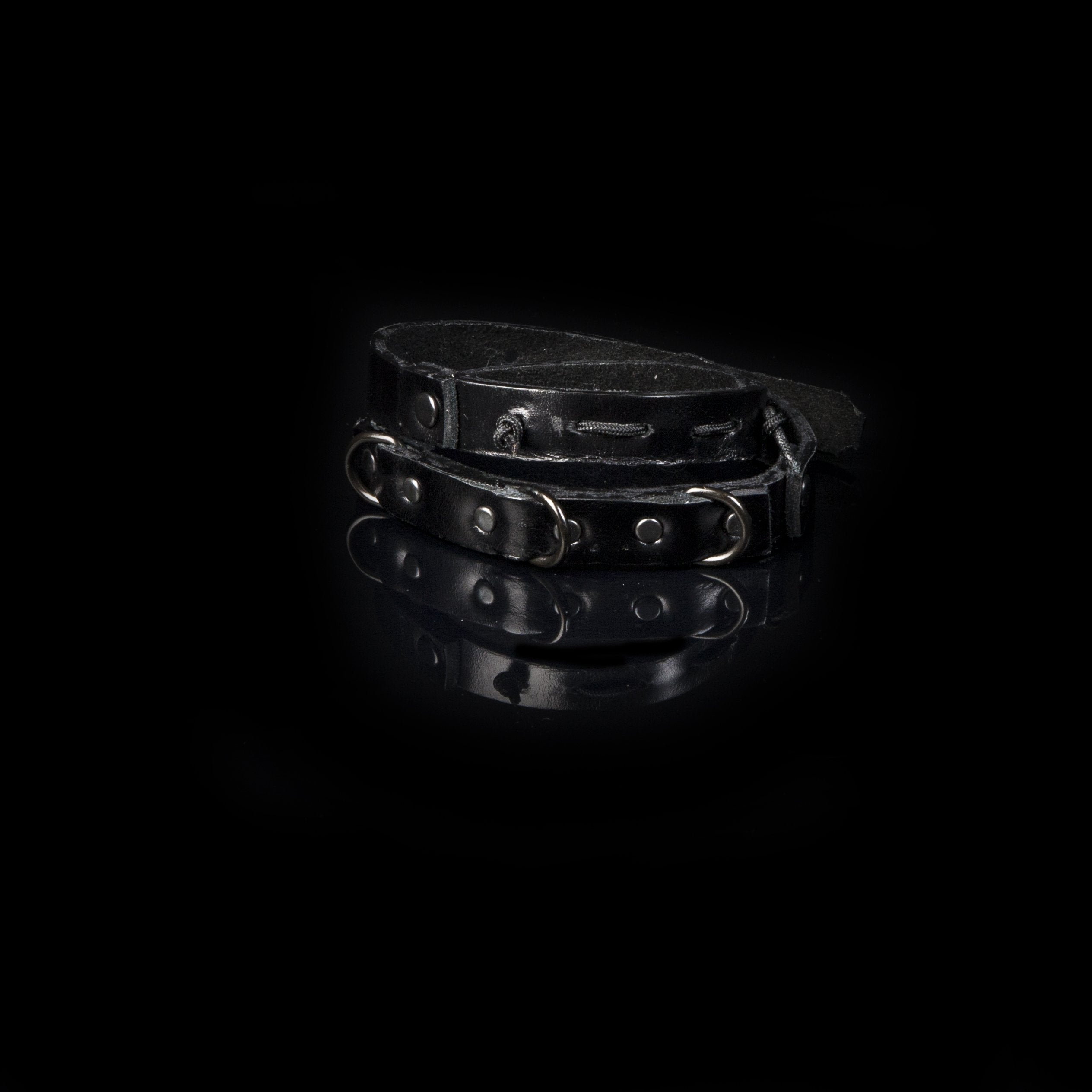 Men's black leather double wrap bracelet featuring gunmetal rivets, industrial rings, and handcrafted layered leather design.