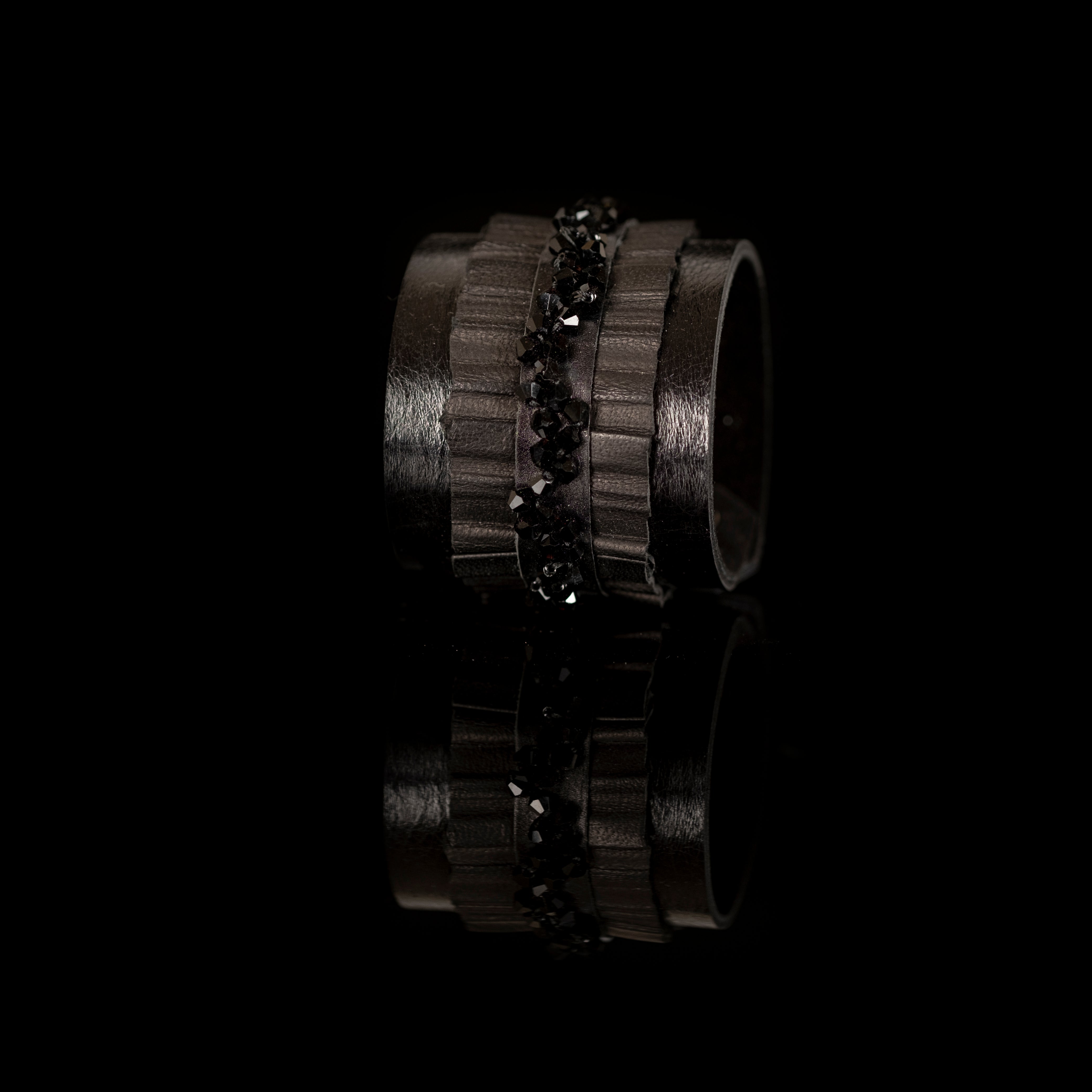 Black leather cuff bracelet with central faceted black crystal band and textured leather layers, handmade statement bracelet by THE DARK