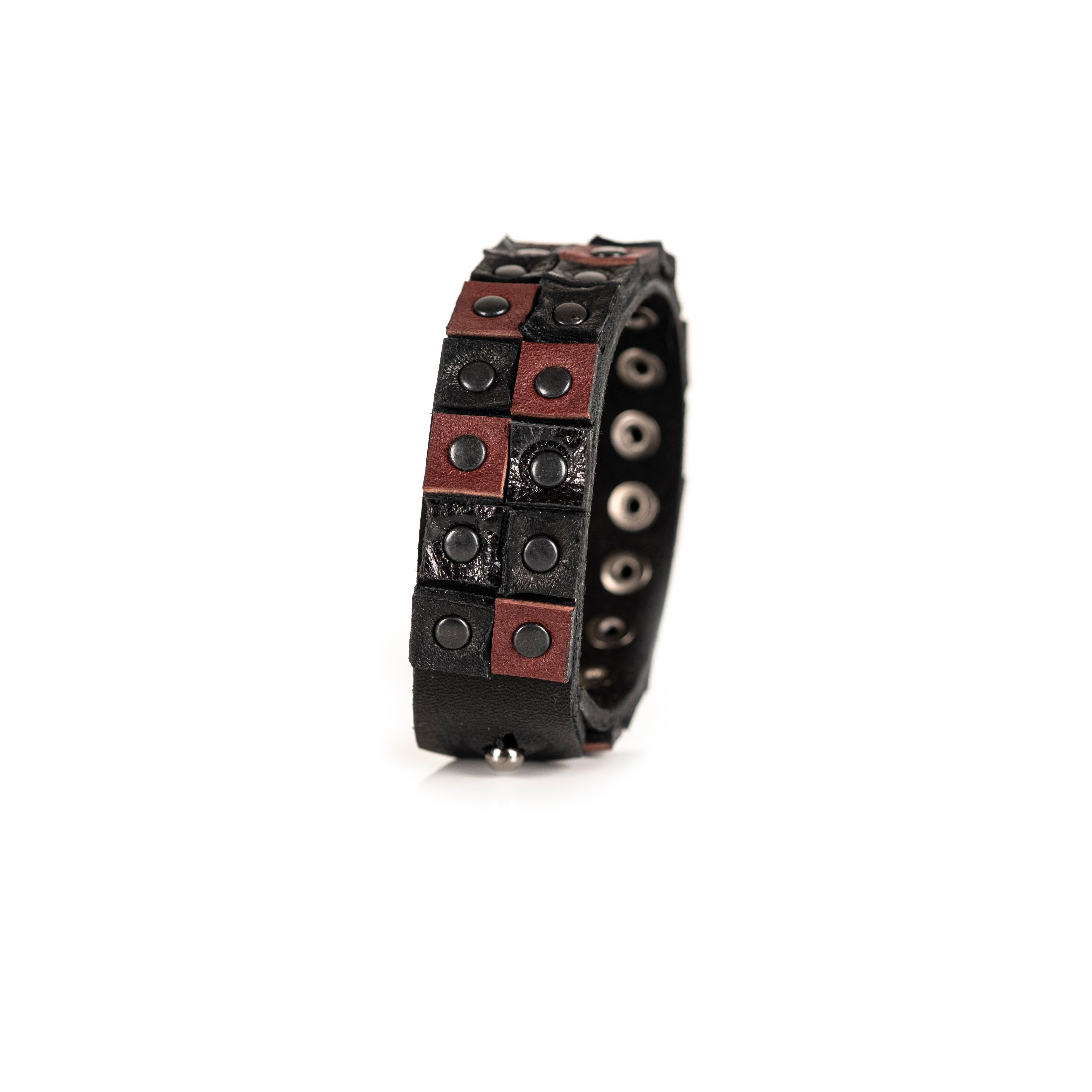 Men's black and brown leather cuff bracelet featuring a double-row studded design with gunmetal rivets and handcrafted leather panels.