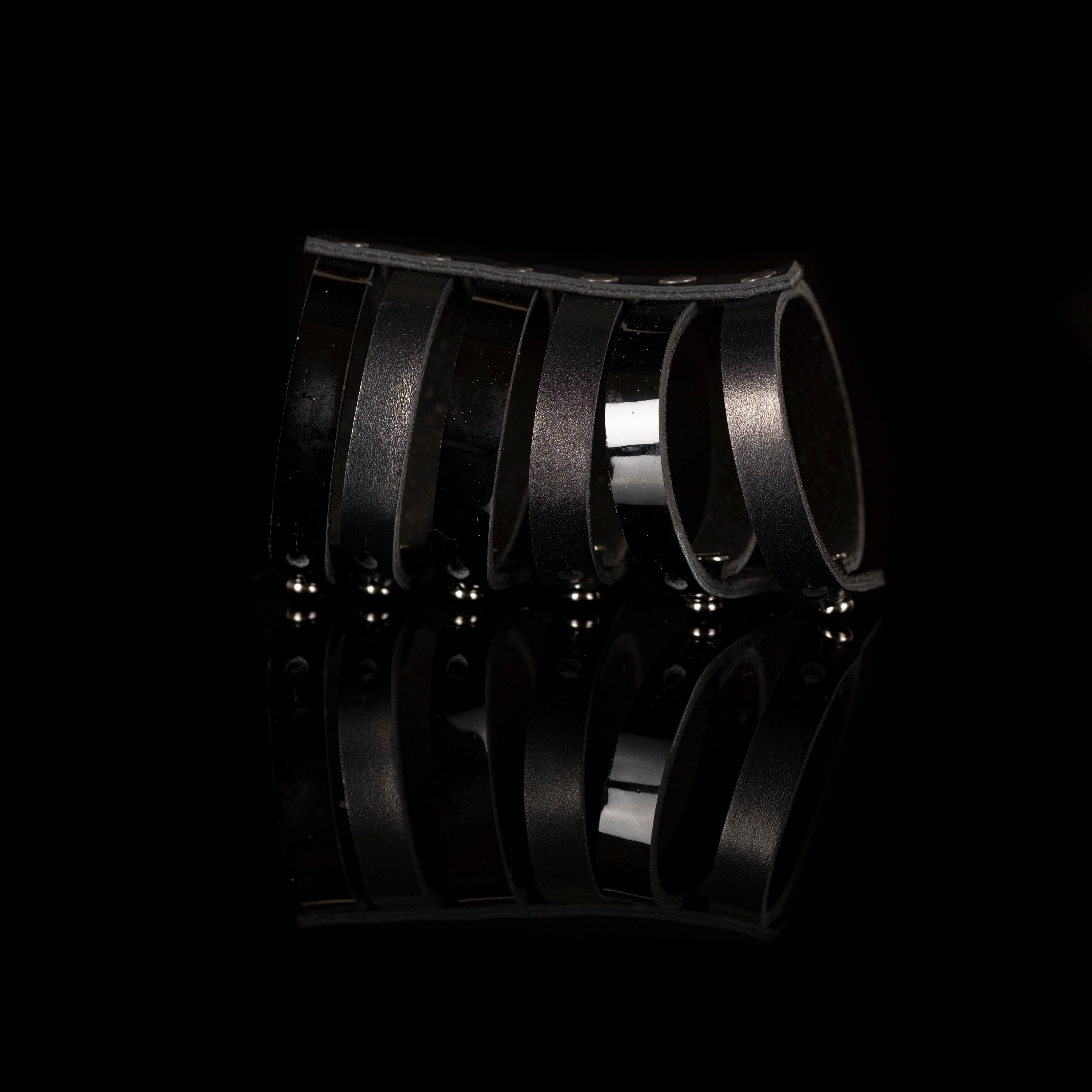 Black leather fringe bracelet with multiple hanging leather straps, handmade sculptural statement cuff by THE DARK