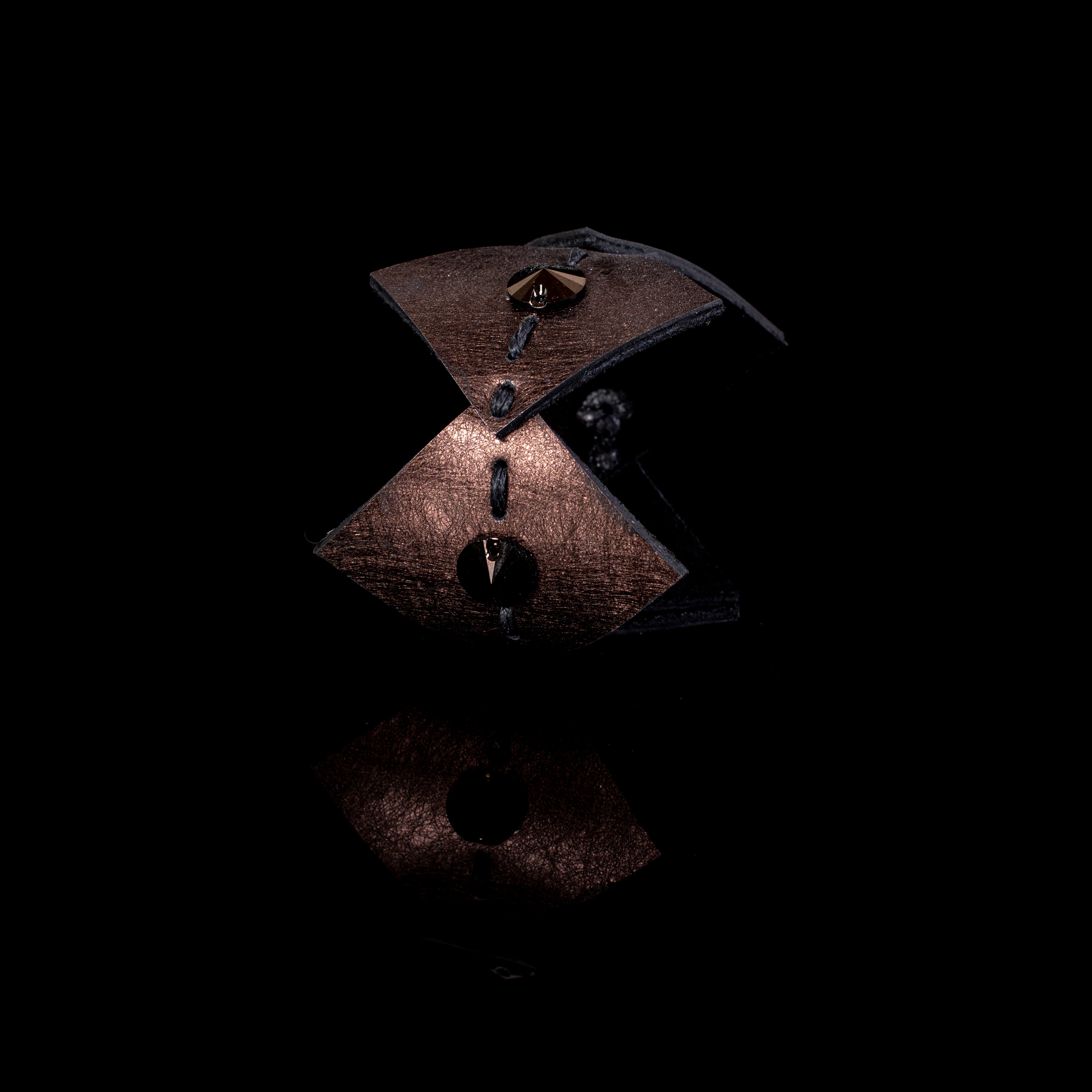 Brown sculptural leather cuff bracelet with layered curved panels and spike stud accents, bold handcrafted statement piece