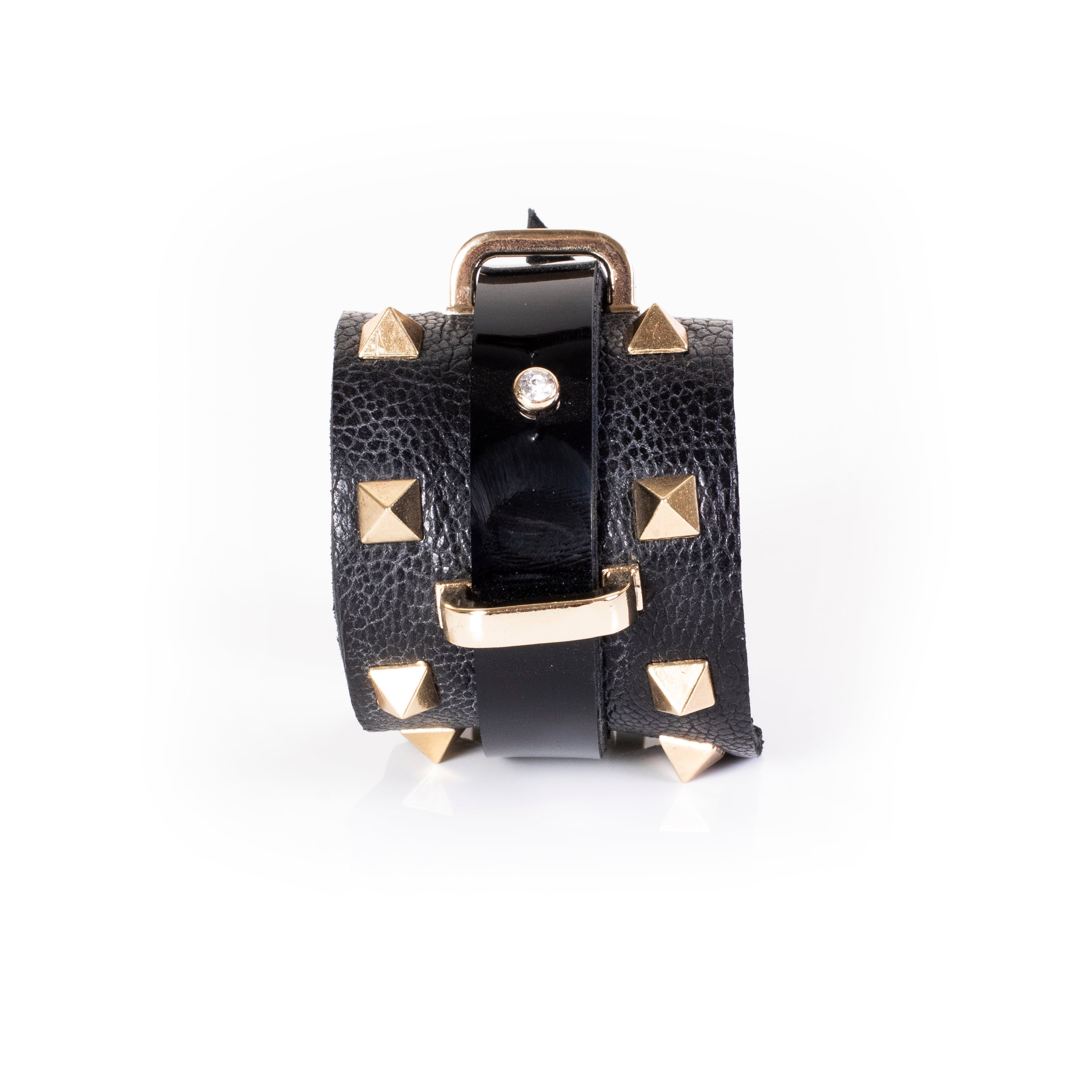 Black leather wrap cuff bracelet with gold pyramid studs, central glossy strip, crystal accent and gold buckle detail, handcrafted statement bracelet for women by THE DARK