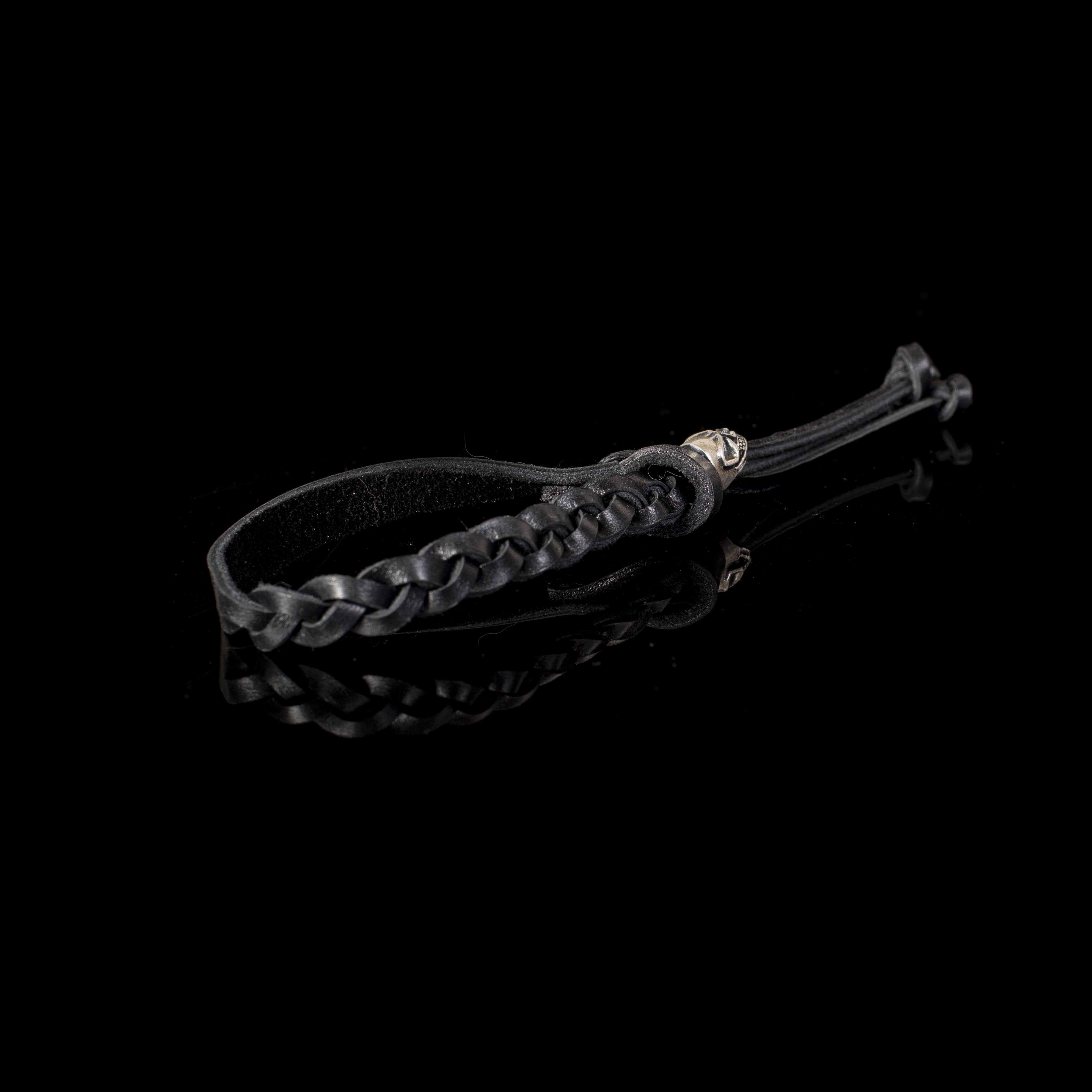 Handmade black braided leather bracelet for men featuring an adjustable sliding closure and silver-tone accent on a white background.