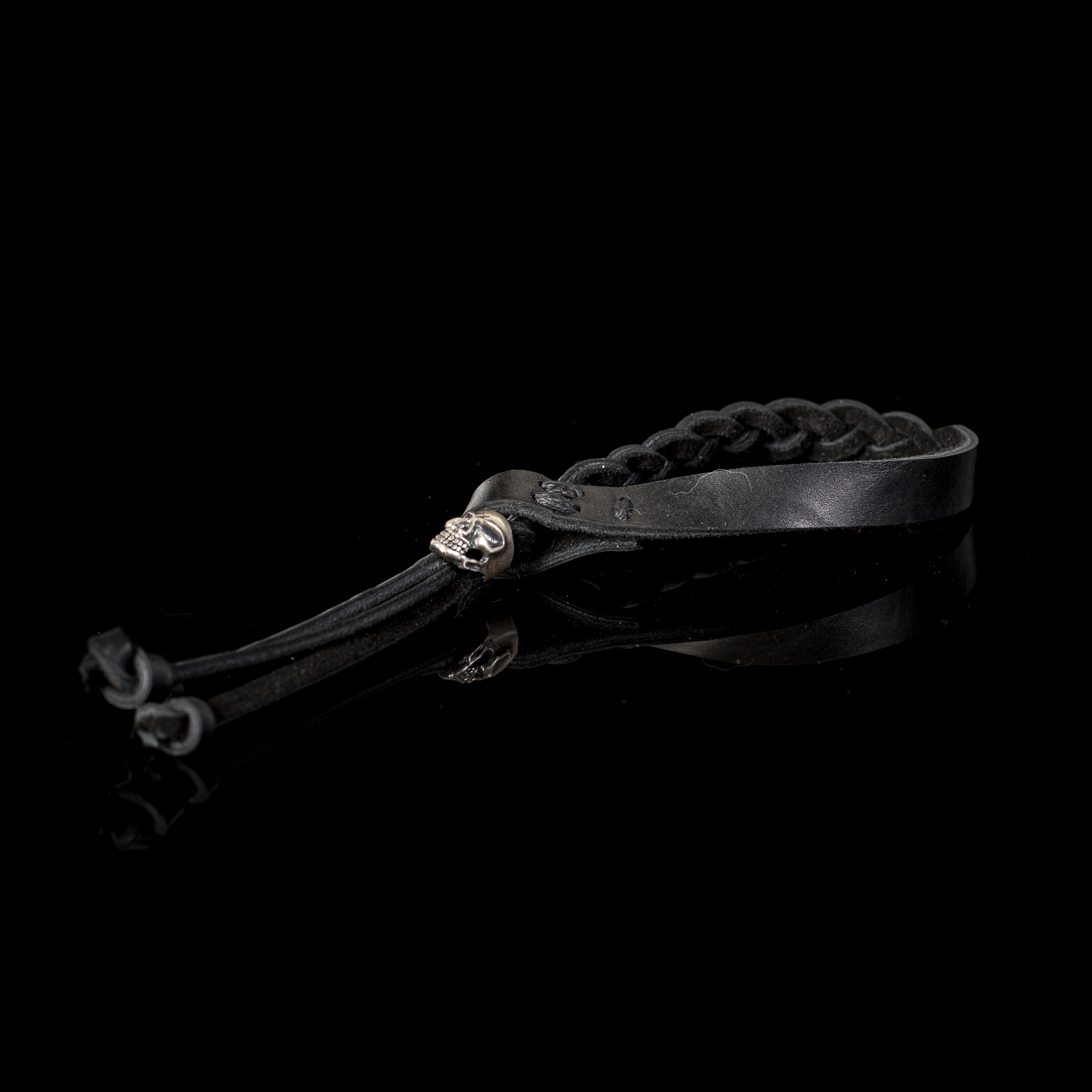Handmade black braided leather bracelet for men featuring an adjustable sliding closure and silver-tone accent on a white background.