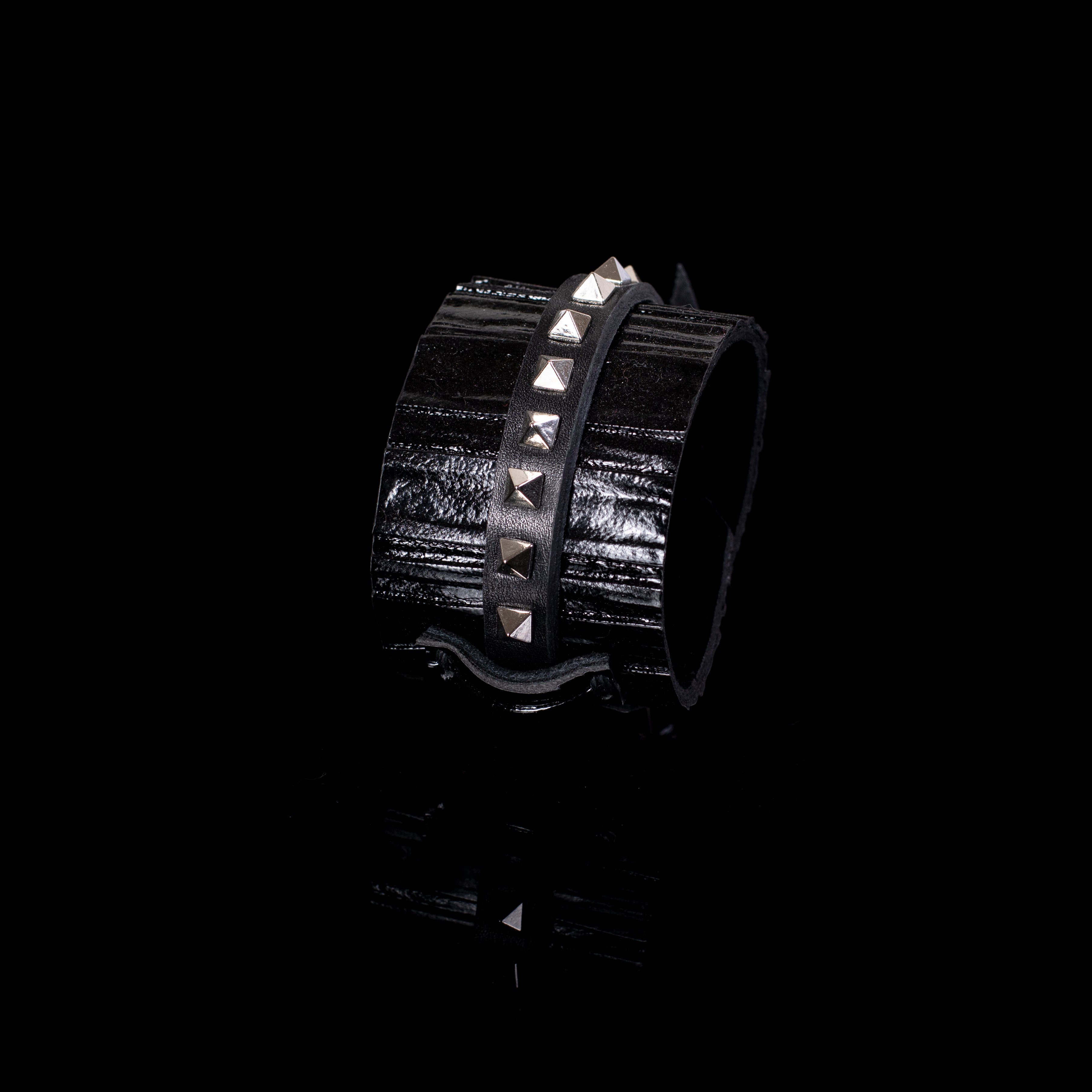 Black patent leather cuff bracelet with central studded leather strap and textured glossy surface, handcrafted wide statement bracelet for women by THE DARK