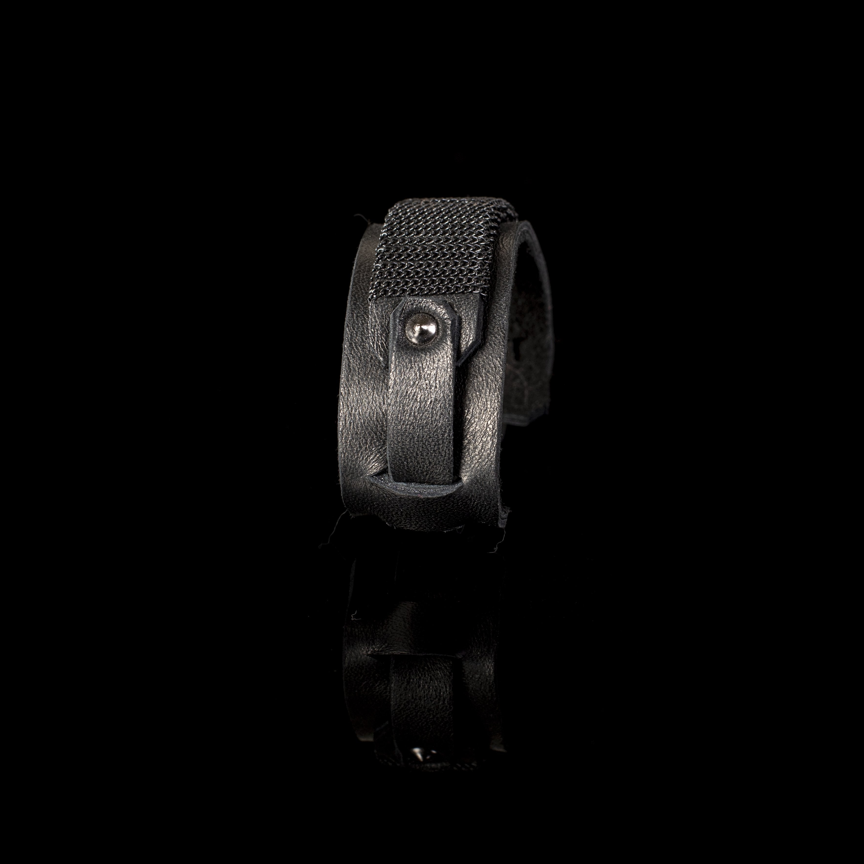 Handmade black leather cuff bracelet featuring an industrial buckle design and textured black mesh detail for men.
