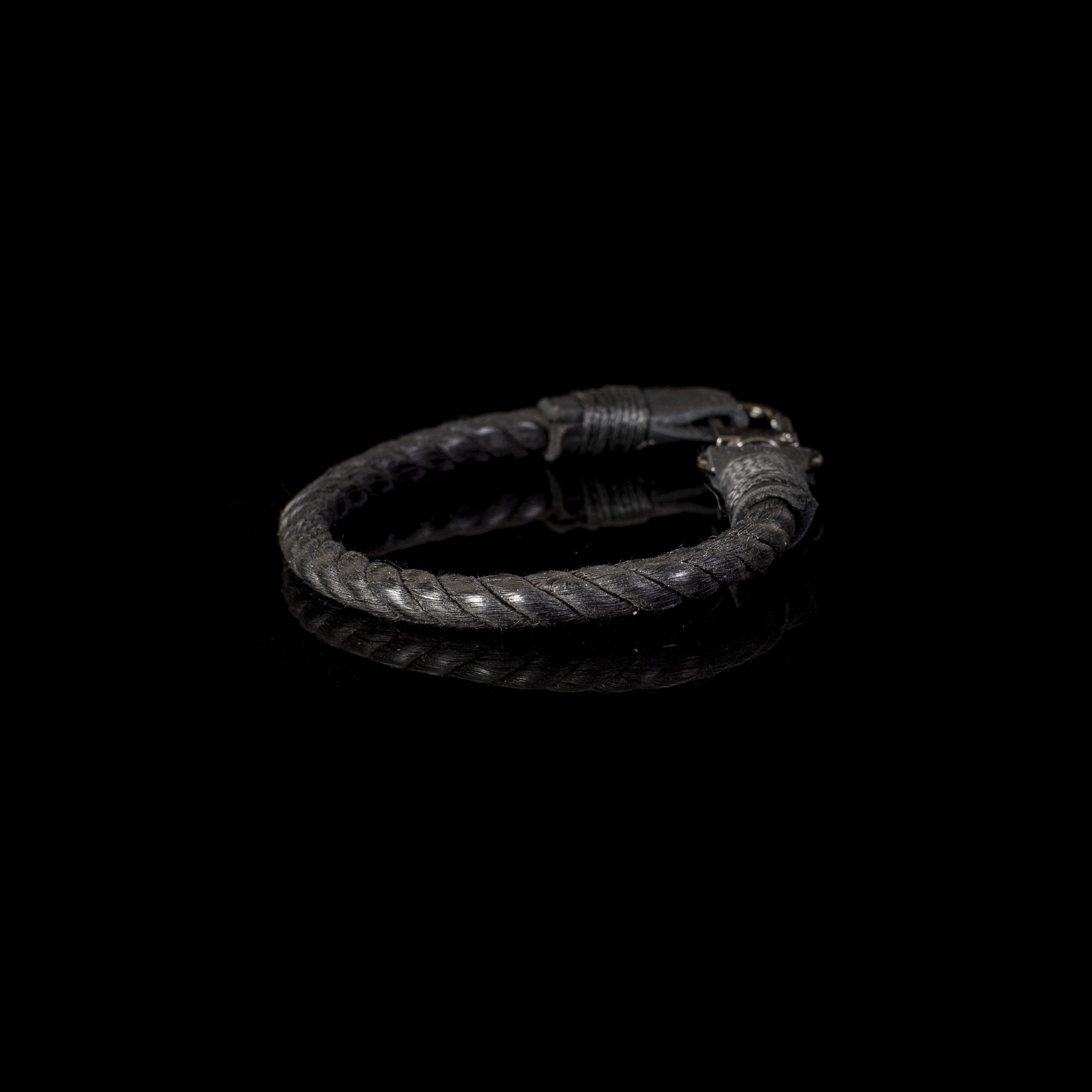 Men's black braided genuine leather bracelet featuring a stainless steel clasp and handcrafted woven design on a white background.