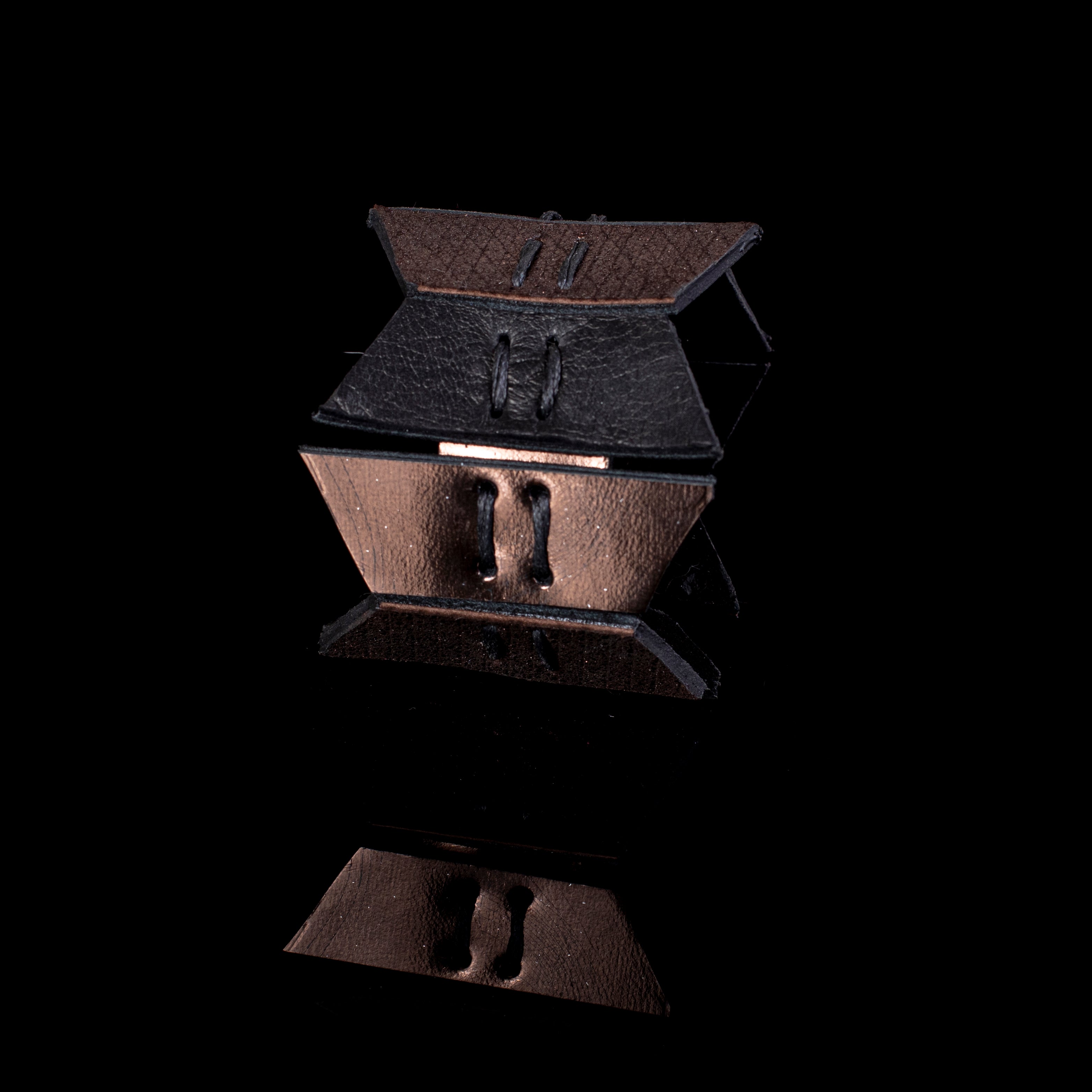 Black and bronze leather cuff bracelet with layered geometric panels and visible stitching, handcrafted wide statement bracelet for women