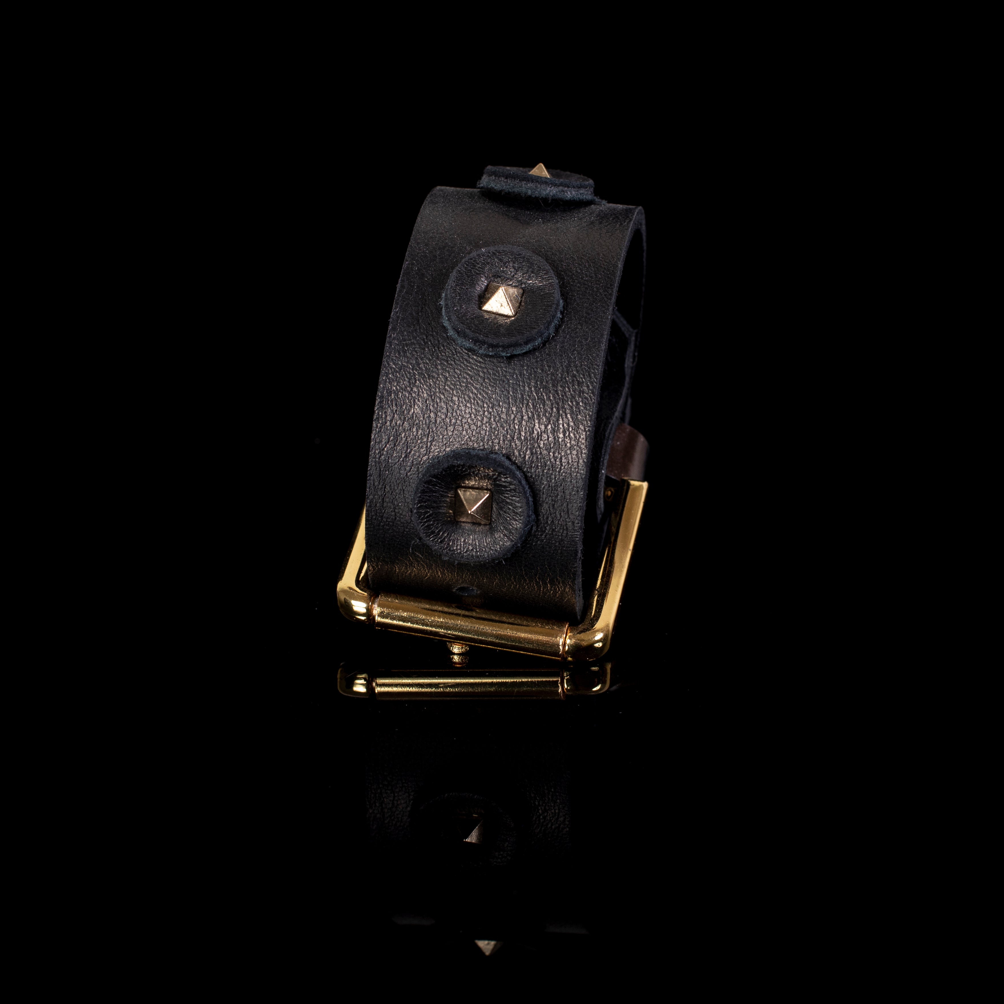 Wide black leather cuff bracelet with circular leather patches and gold pyramid studs, handcrafted statement bracelet with gold buckle for women