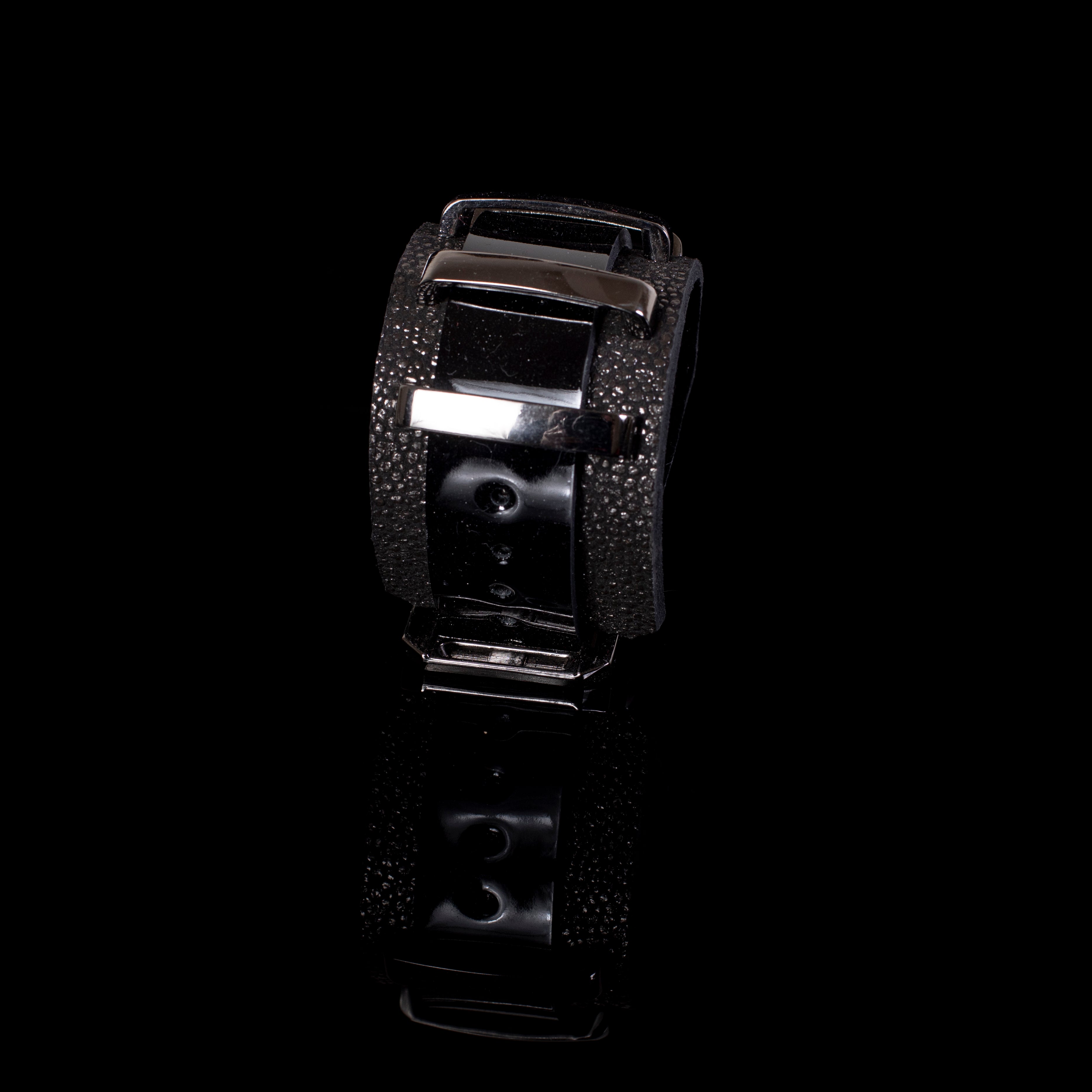 Black leather cuff bracelet with glossy panels and textured edges, wide structured bracelet with metal bar detail for women