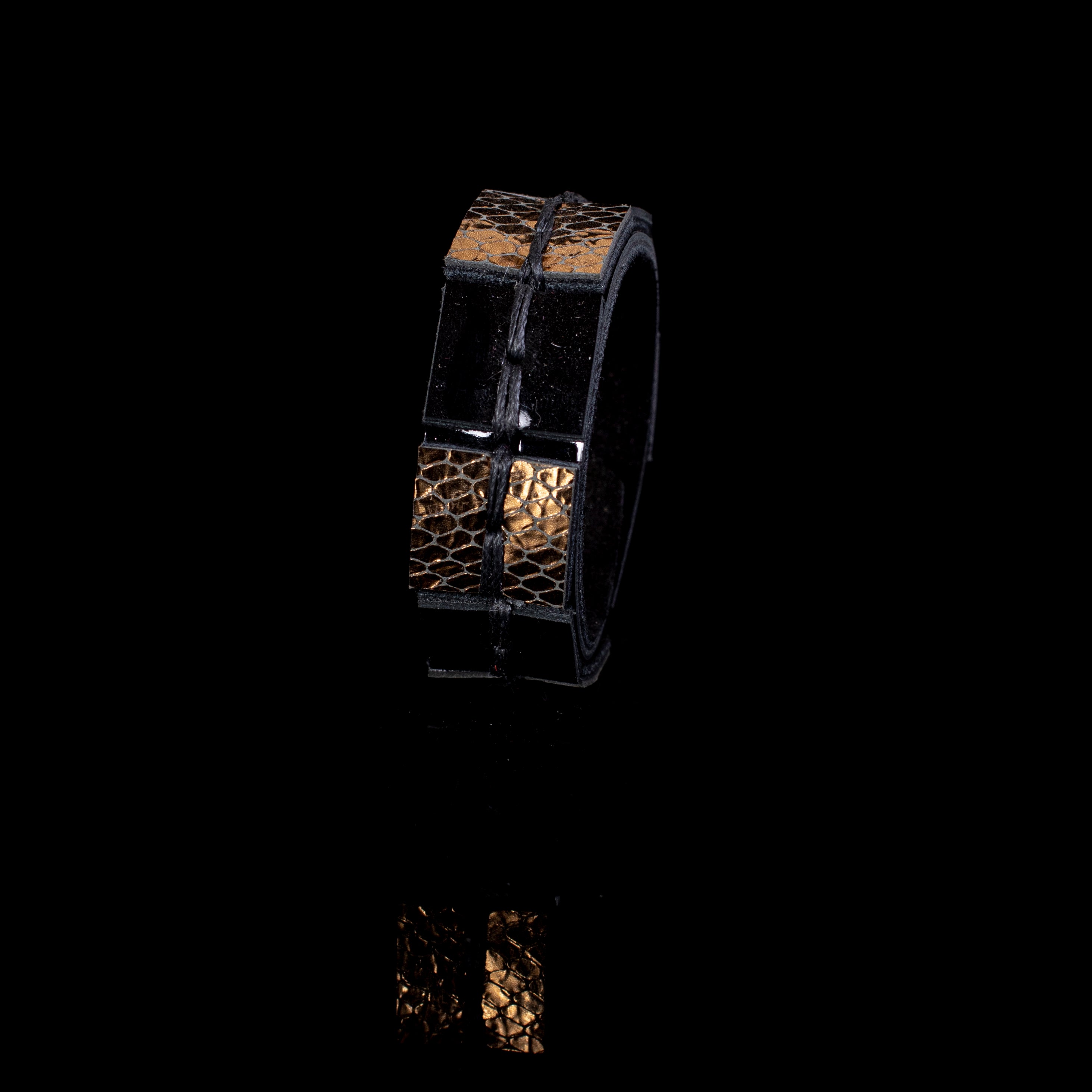 Black leather cuff bracelet with gold python textured panels and visible hand stitching, handcrafted structured statement bracelet for women by THE DARK