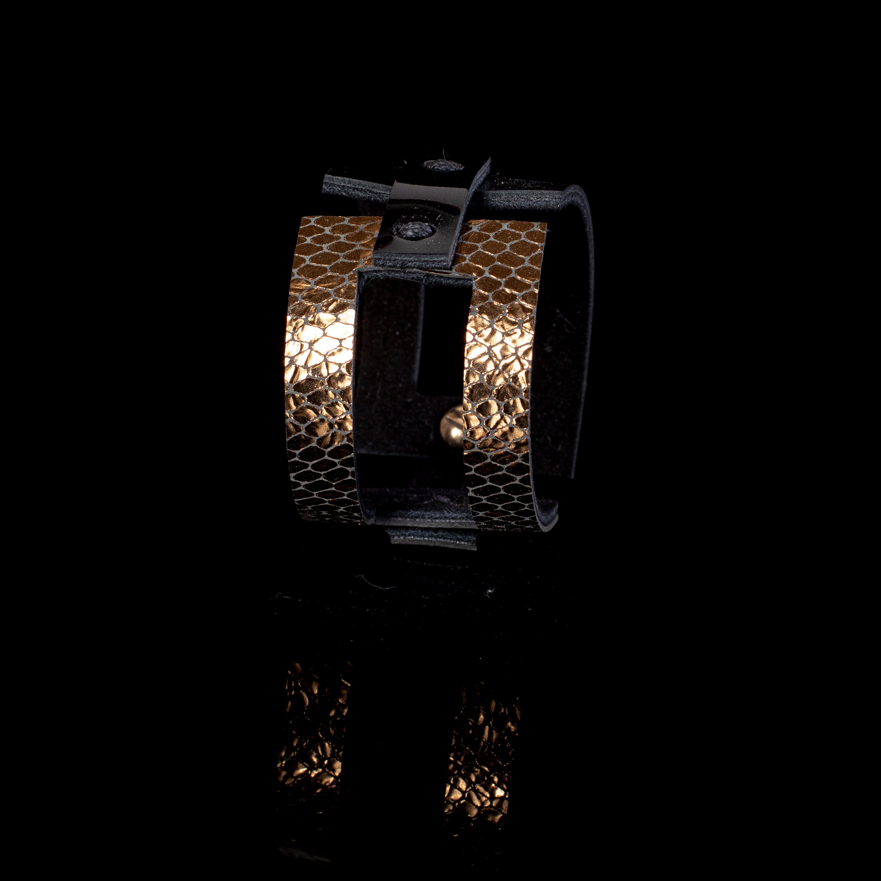 Black leather sculptural cuff bracelet with vertical gold python textured bands and open architectural design, handcrafted statement bracelet for women by THE DARK
