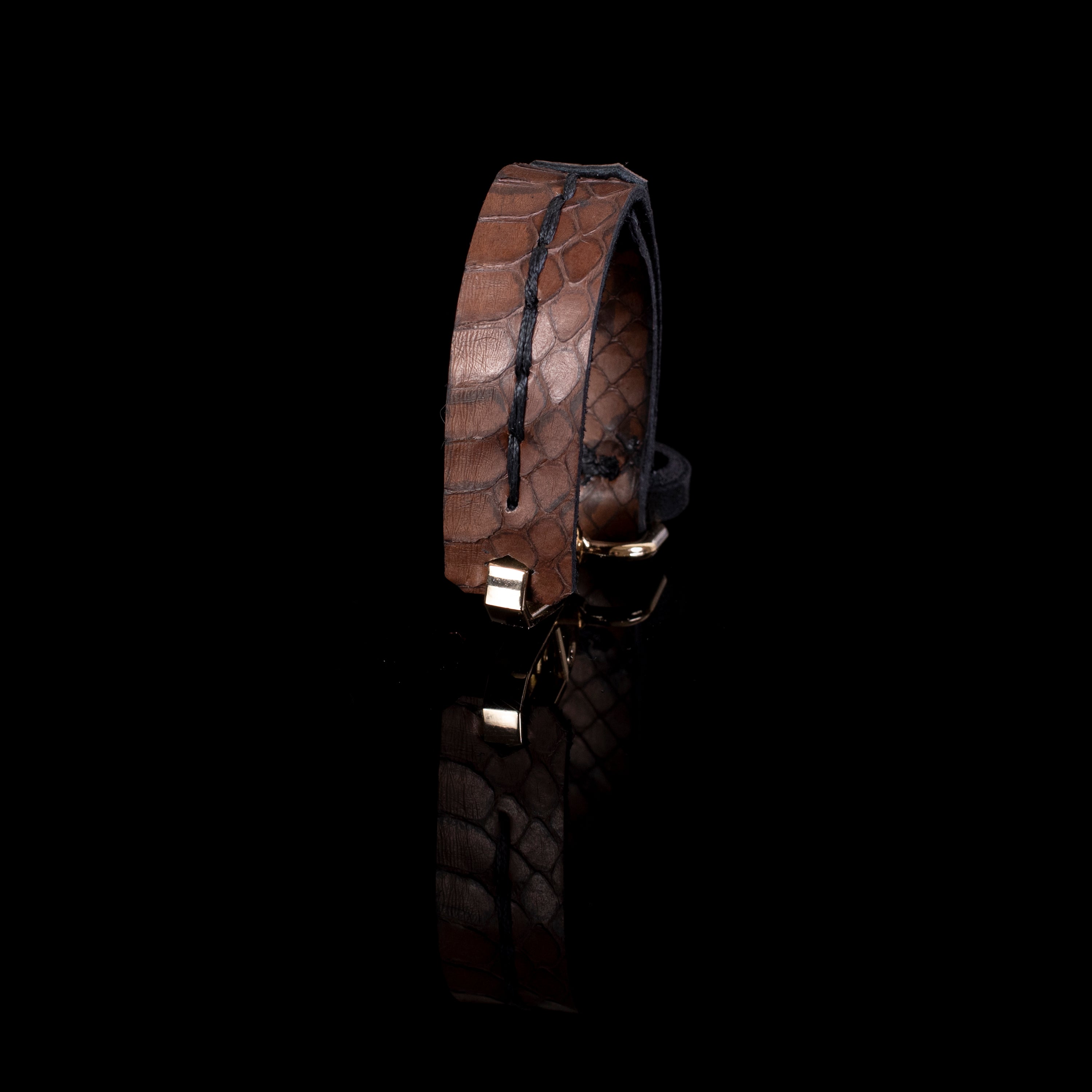 Brown textured leather cuff bracelet with vertical stitching and gold clasp, reptile pattern minimalist statement bracelet for women